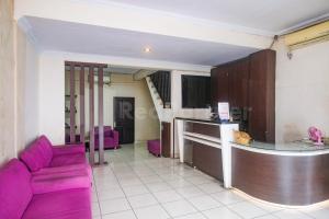 un soggiorno con un divano viola e una cucina di Bies Malioboro Hotel RedPartner a Yogyakarta