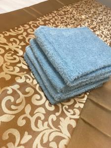 a stack of blue towels sitting on a carpet at B&K Numabukuro in Tokyo