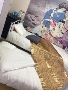 a room with two beds and a painting on the wall at B&K Numabukuro in Tokyo