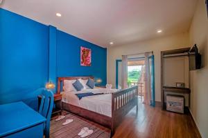 a bedroom with blue walls and a bed with a desk at Zen NamKhan Riverside in Luang Prabang +79 photos