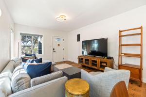 a living room with a couch and a flat screen tv at The Berkeley Haven in Berkeley