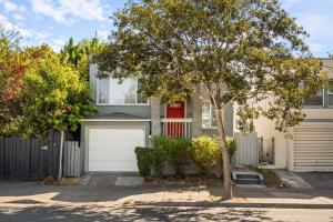 a white house with a red door and a tree at The Berkeley Haven in Berkeley