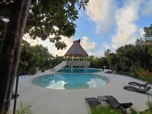 a swimming pool with a gazebo in a resort at Casa Balam en Puerto Morelos in Puerto Morelos