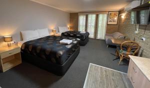 a hotel room with two beds and a living room at Tropicana Motor Inn in Cowes +58 photos