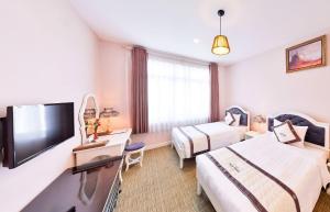 Postel nebo postele na pokoji v ubytování Ngoc Phat Dalat Hotel