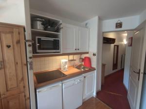 Una pequeña cocina con fregadero y microondas. en Appartement rénové 2 pièces, 4 pers. à Isola 2000, proche pistes - FR-1-292-215, en Isola