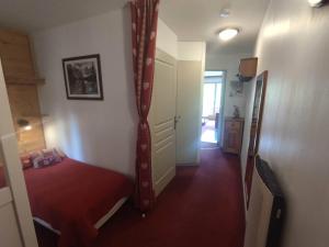 Un dormitorio pequeño con una cama y un espejo. en Appartement rénové 2 pièces, 4 pers. à Isola 2000, proche pistes - FR-1-292-215, en Isola