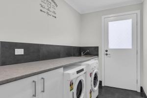MiradorにあるMirador Zenscape - 5 bedroomのキッチン(洗濯機2台、シンク付)