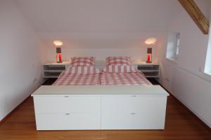 a bedroom with a white bed with two red pillows at Villa Bergfrieden in Oberstaufen