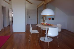 a kitchen with a table with chairs and a bowl of fruit at Villa Bergfrieden in Oberstaufen