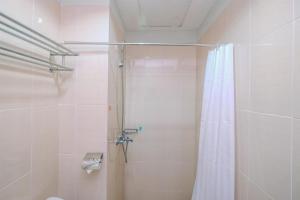 a bathroom with a shower with a shower curtain at Fully Furnished with Luxury Design Studio The Oasis Apartment By Travelio in Cikarang