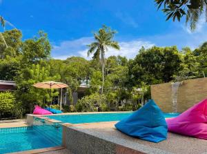a swimming pool with colorful pillows next to a resort at Pana Long Beach Resort - SHA Plus in Ko Lanta