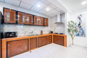 a kitchen with wooden cabinets and a sink at Cozystay Center of Patong near Bangla Road in Patong Beach +8 photos