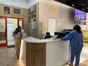 a woman standing at a counter in a store at Eagle Town Serviced Apartment in Ulaanbaatar