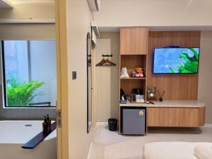 a bathroom with a tub and a tv in a room at Urban room samed in Ko Samed