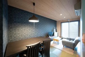 a dining room with a table and chairs and a couch at PINN-S1E6 in Sapporo