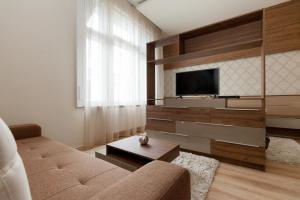 a living room with a couch and a flat screen tv at Holidays Concept in Budapest