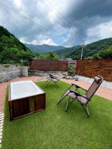 two chairs and a tub in a yard with grass at OUR HOUSE-Mie in Nishiki
