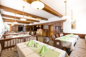 a restaurant with tables and chairs with green napkins at Pension Bergfried in Hallstatt