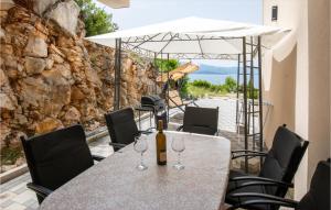 a table and chairs with wine glasses on a patio at 3 Bedroom Nice Apartment In Komarna in Komarna