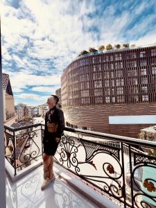 a man standing on the balcony of a building at Nature Hotel - Win Happy in Da Lat