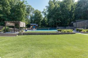 a backyard with a swimming pool and a lawn at Z Presidential Suite in Upper Marlboro