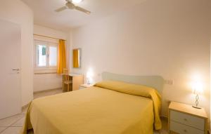 sypialnia z żółtym łóżkiem i oknem w obiekcie Pet Friendly Apartment In Ricadi w mieście Ricadi