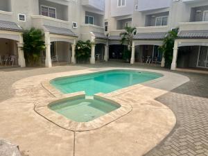 a swimming pool in front of a building at Montagu Villa Apt14 in Flic-en-Flac