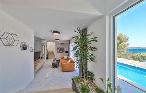 a living room with a large window and a pool at Lovely Home In Seget Donji in Trogir