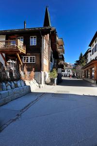 an empty street in front of a wooden house at Alte Post Saas-Fee in Saas-Fee