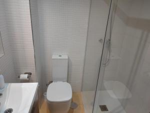 a white bathroom with a toilet and a shower at El Refugio de Insuela in San Pedro