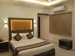 a hotel room with a bed and a window and avertisement at Hotel Centauri in Thiruvalla