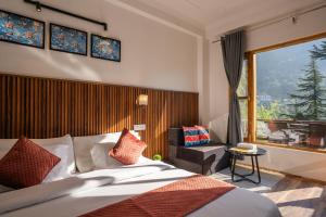 a hotel room with a bed and a large window at Alt Life Manali, Old Manali in Manāli