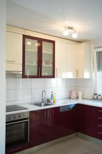 a kitchen with brown cabinets and a sink at Apartman Tinaa in Ljubuški