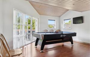 a living room with a pool table and a tv at Beautiful Home In Væggerløse With Sauna in Bøtø By