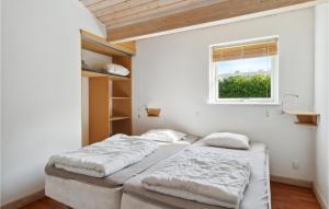 two beds in a room with a window at Beautiful Home In Væggerløse With Sauna in Bøtø By +12 photos