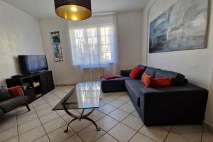 Una sala de estar con un sofá azul y una mesa de cristal. en Villa Jasmin Thionville, en Thionville