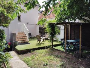 un patio con una mesa y sillas y una mesa y una casa en Villa Jasmin Thionville, en Thionville