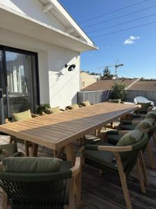 une table et des chaises en bois sur une terrasse dans l'établissement Villa Rompsay, à La Rochelle