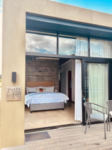 a bedroom with a bed on the deck of a house at Cellar Pods Blue in Robertson +8 photos