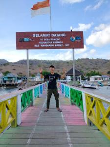 a man standing on a bridge over the water at Atta Ratu Homestay komodo in Komodo +13 photos