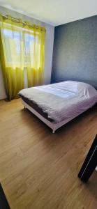 a bed in a bedroom with a wooden floor at Gite Alsacien in Roggenhouse