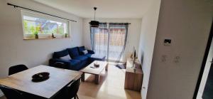 a living room with a blue couch and a table at Gite Alsacien in Roggenhouse