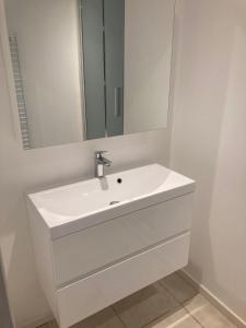 a bathroom with a white sink and a mirror at Belle villa spacieuse avec piscine privée, semi climatisée- 10 couchages, wifi, proche canal du midi et à 4 km de la mer LXPIN7 in Portiragnes