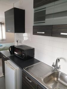a kitchen with a sink and a microwave at Studios in Ely