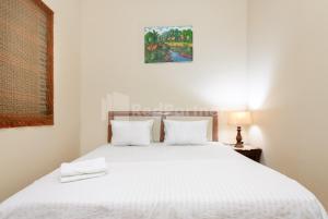 a bedroom with a white bed with two pillows at SR Residence near Mall Ciputra Cibubur Mitra RedDoorz in Bekasi