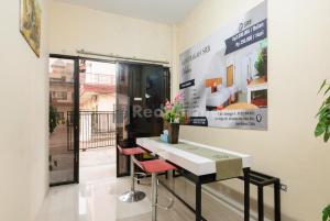 a room with a white table and two red chairs at SR Residence near Mall Ciputra Cibubur Mitra RedDoorz in Bekasi