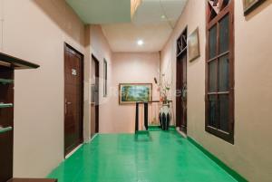 a hallway with a green floor in a house at SR Residence near Mall Ciputra Cibubur Mitra RedDoorz in Bekasi