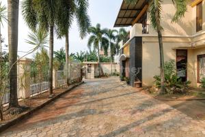 a driveway leading to a house with palm trees at SR Residence near Mall Ciputra Cibubur Mitra RedDoorz in Bekasi