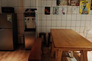 a kitchen with a wooden table and a refrigerator at Bao Dao Da Lou in Suao